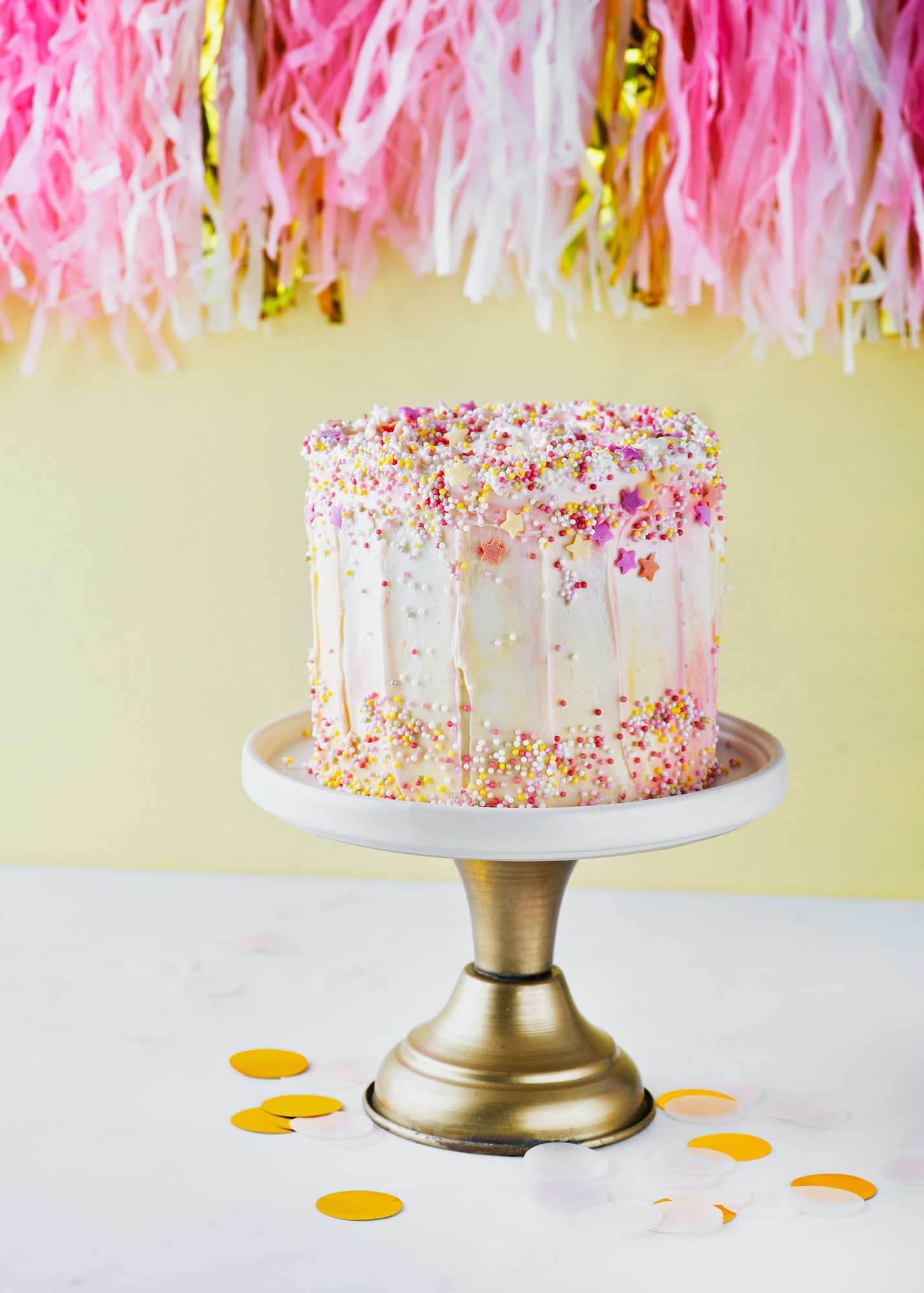 colorful-birthday-cake-with-sprinkles-on-a-yellow-background-.jpg